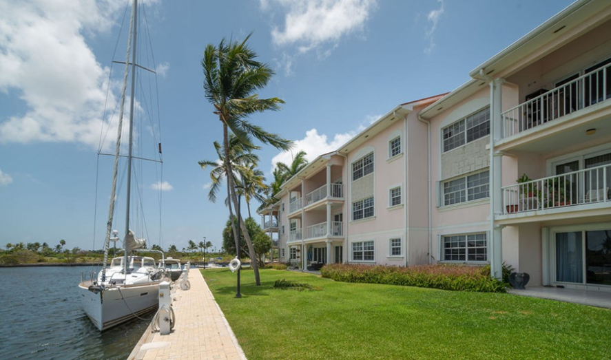 The Waterways condominiums on Mitchell's Creek, with a yacht moored along the canal-front dock